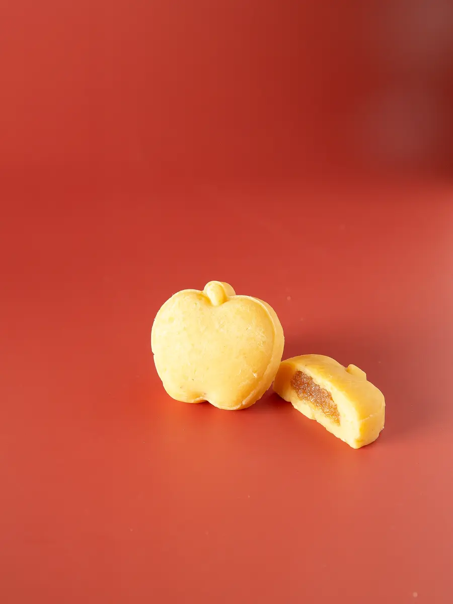 An apple-shaped bean cake, cut open, on red (photograph supplied by the client)