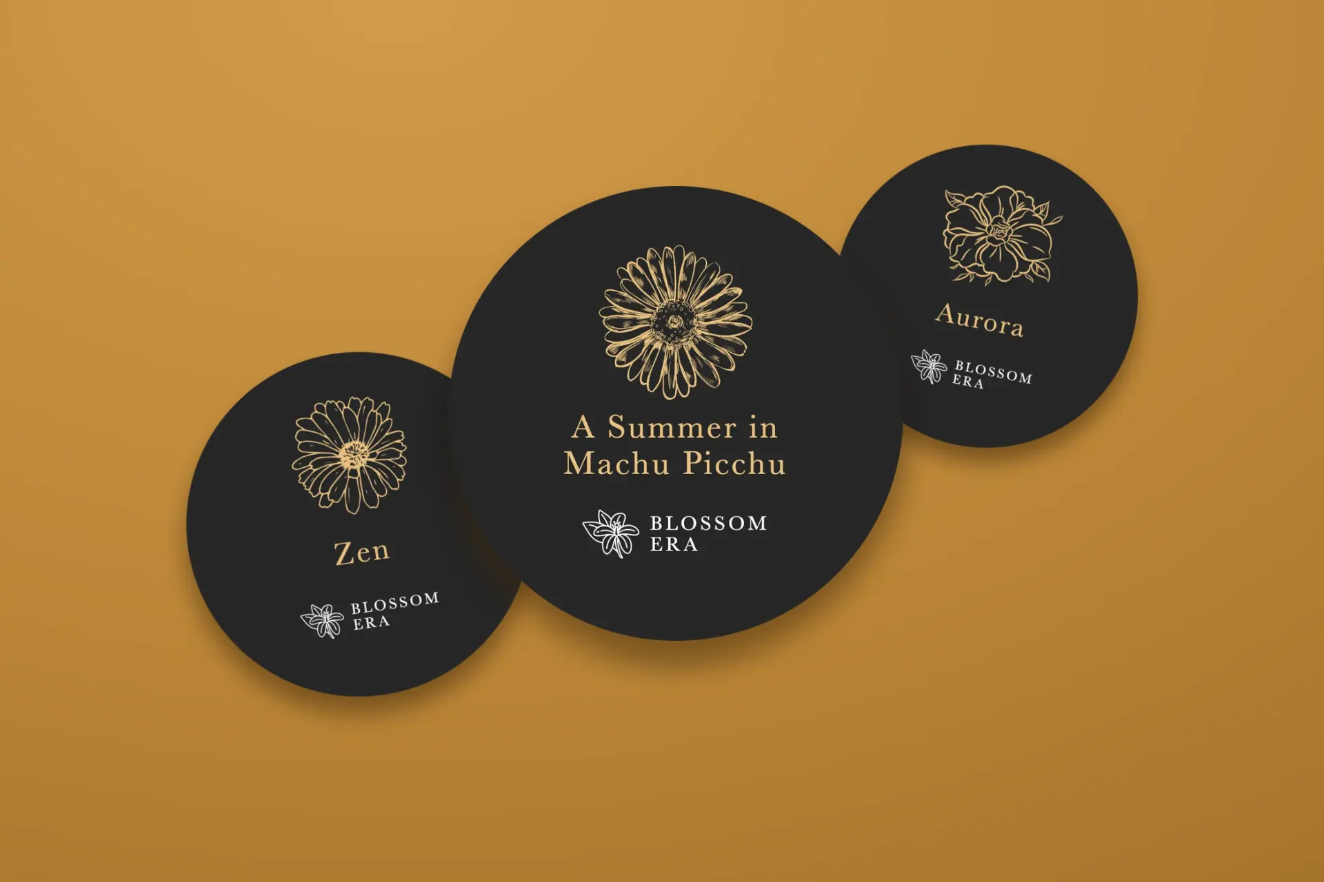 Blossom Era lids: Zen, A Summer in Machu Picchu and Aurora, charcoal lids with gold drawings and names on a brass ground