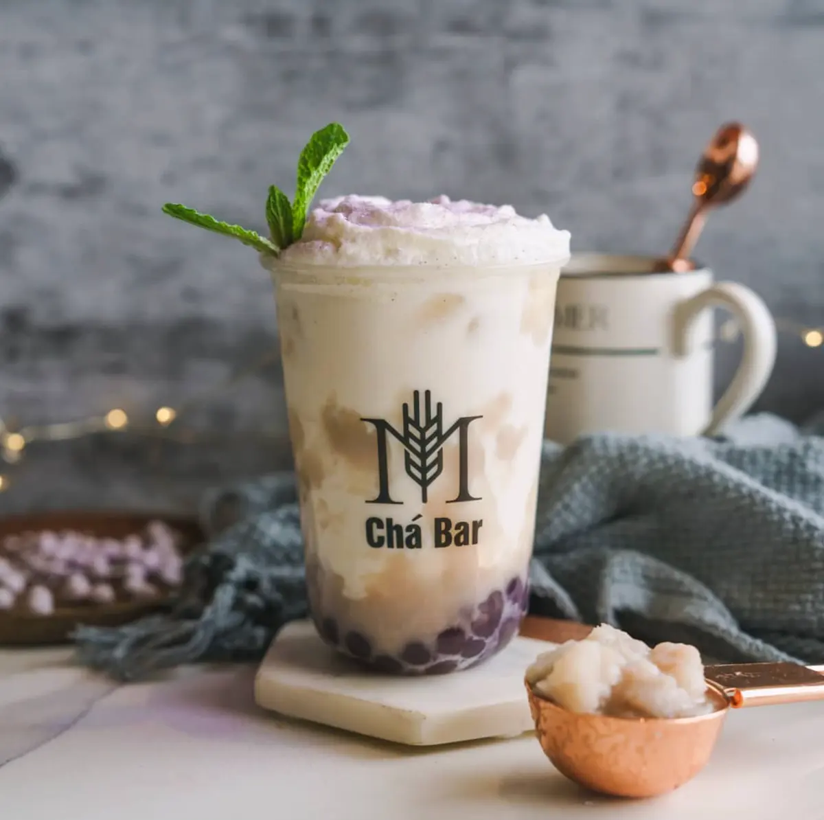 A taro milk tea with the M Chá Bar mark on the cup