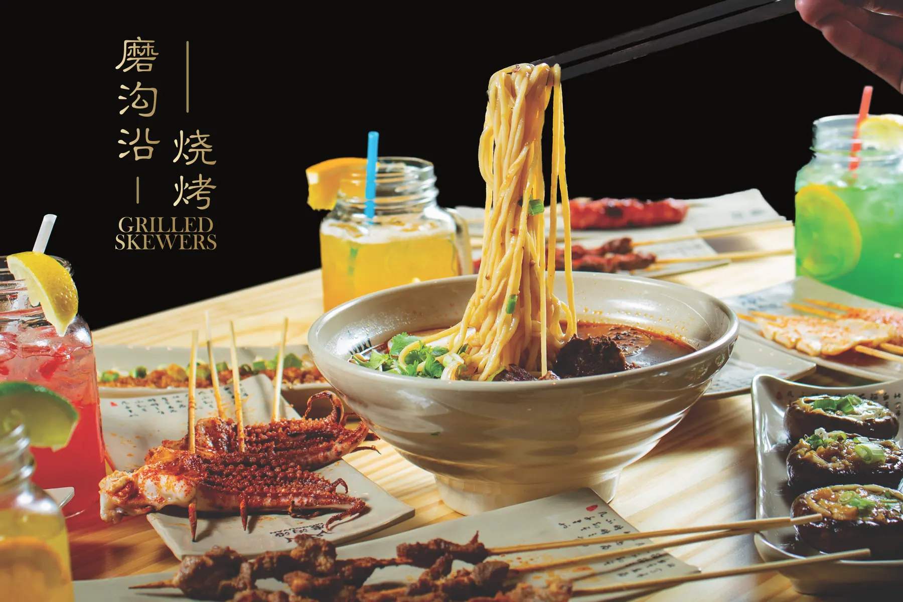 Storefront window poster: the gold vertical lockup “磨沟沿 | 烧烤 Grilled Skewers” beside a bowl of lifted noodles and a table of skewers