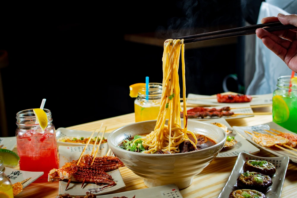 Original archival photograph of lifted noodles, a bowl and small plates