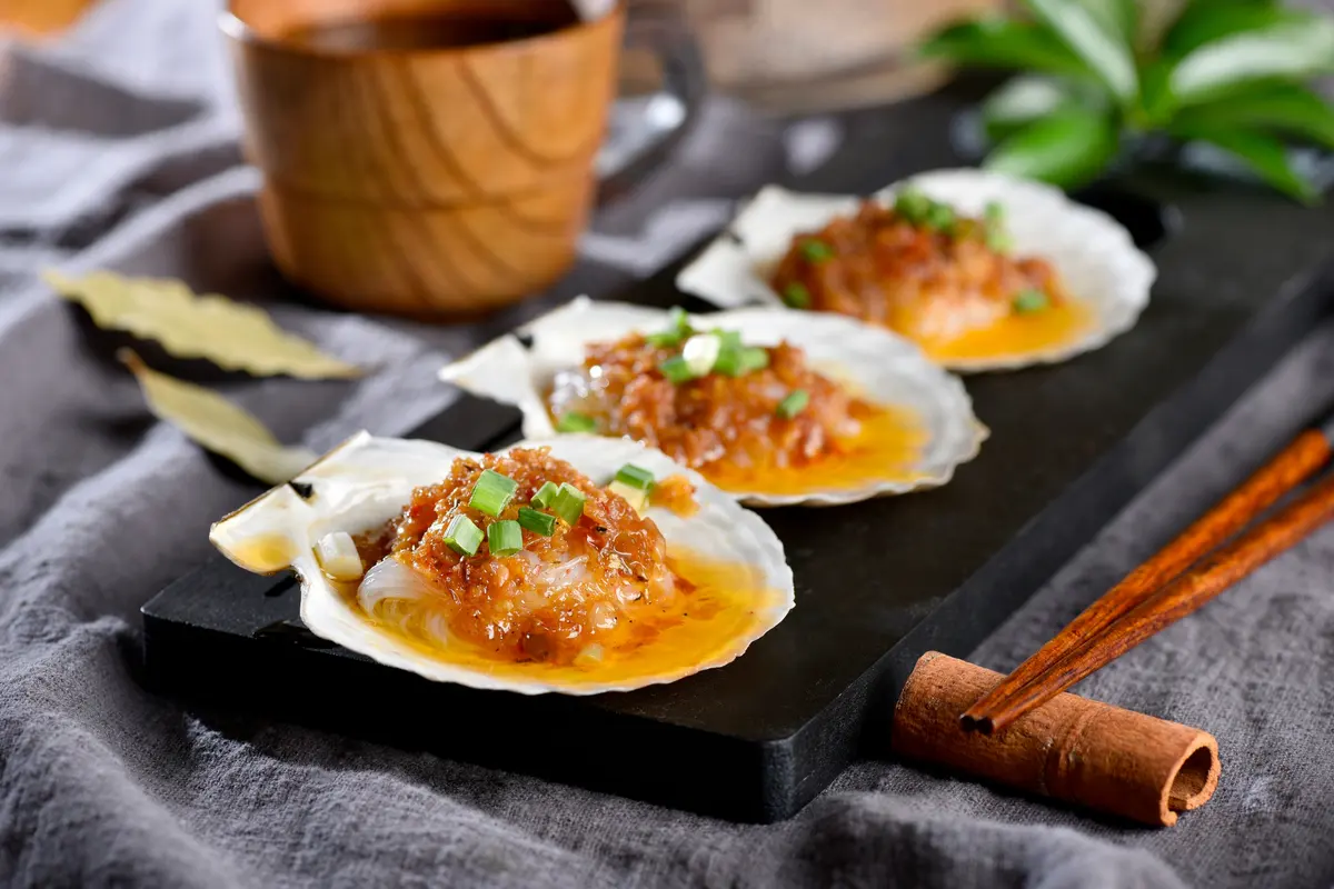 Garlic vermicelli scallops on a black board